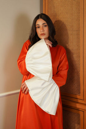 Woman wearing a red and white outfit against a wooden panel background
