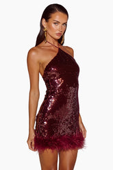 Woman wearing a sparkly burgundy dress with feather details 
