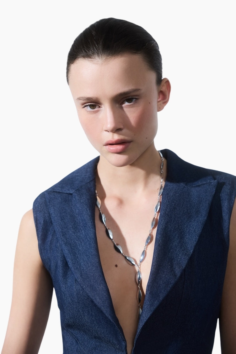 model wearing a Structured denim mini dress with sharp shoulder pads and a bold blazer neckline.