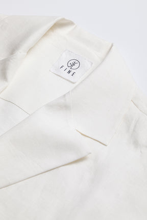 Close-up of a white garment with a 'FIRE' label on a light gray background