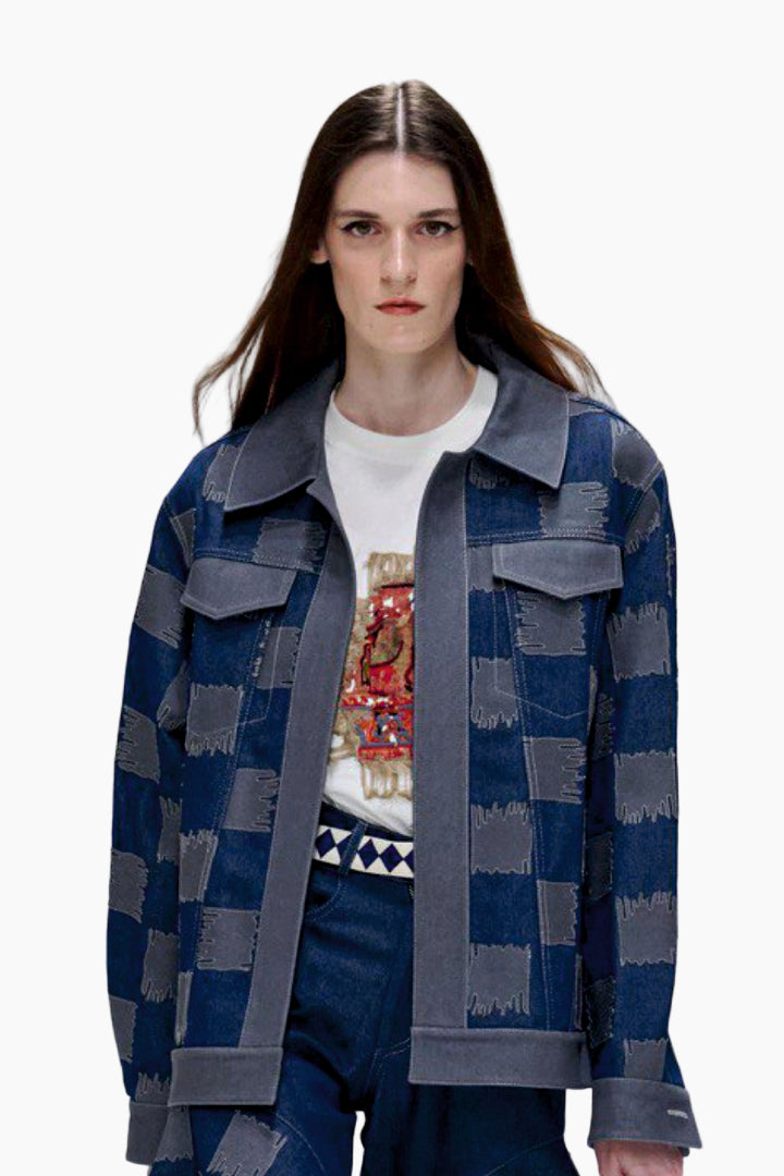 Woman wearing a blue and gray checkered jacket over a white shirt with a colorful design.
