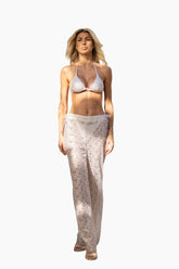 Woman wearing a white lace pants and a white bikini