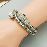 Silver bracelet with intricate design on a wrist against a neutral background