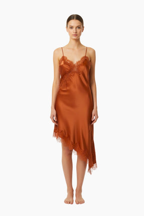 Woman wearing a rust-colored satin slip dress 