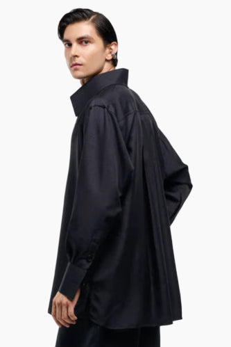 Person wearing a black oversized shirt on a white background