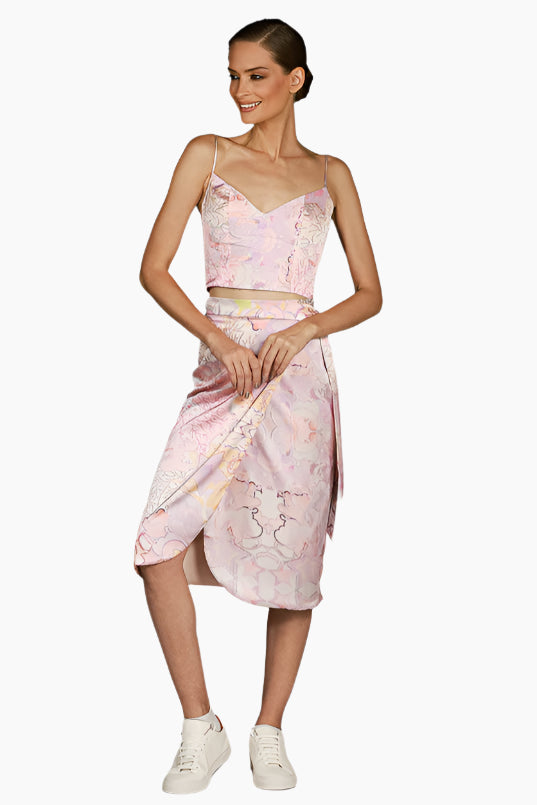 Woman wearing a pink floral skirt with matching top