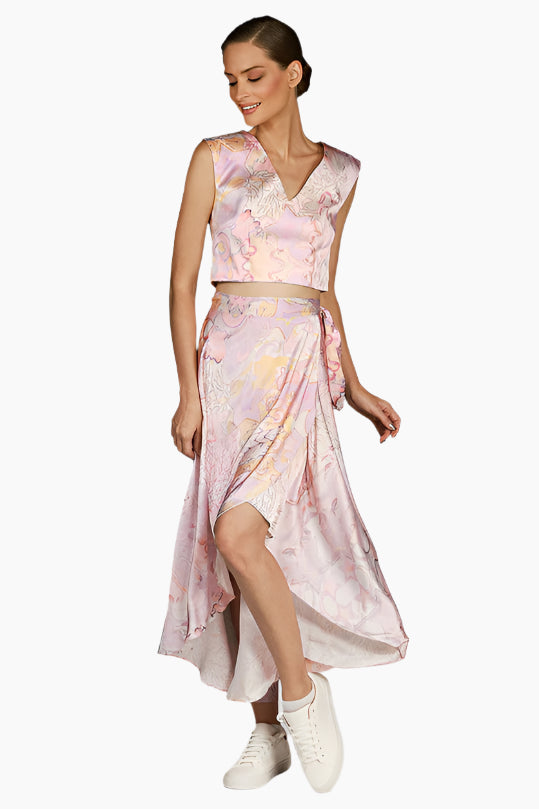 Woman wearing a pink floral dress , Flow wrap design with matching sleeveless top