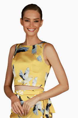 Woman wearing a yellowfloral sleeveless top with a matching skirt