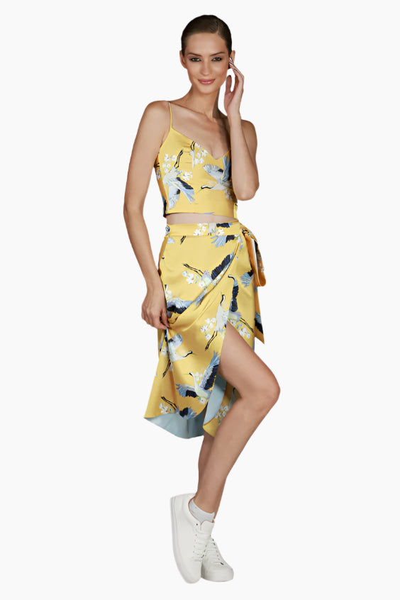 Woman wearing a yellow floral patterned long skirts with matching tops