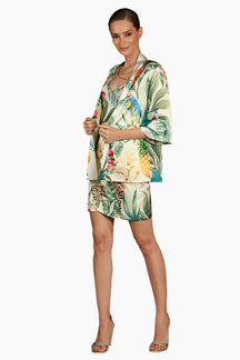 Woman wearing a tropical print outfit skirt, top and kimono 