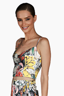Woman wearing a colorful floral top and skirt 