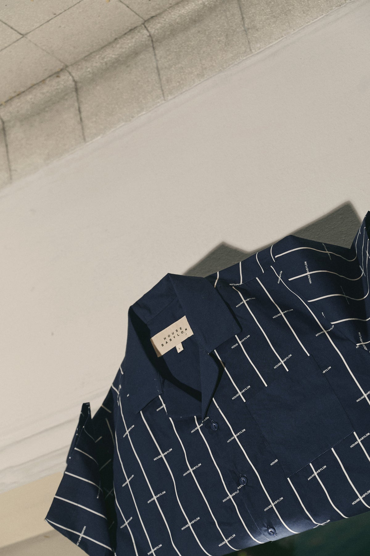 Navy blue garment with white cross pattern, House Babylon stripe shirt - Navy