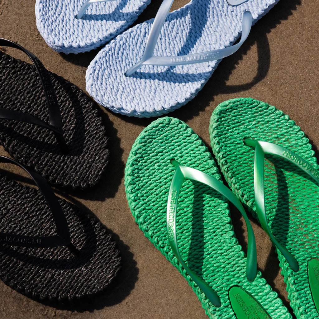 Blue and green textured sandals on a brown surface