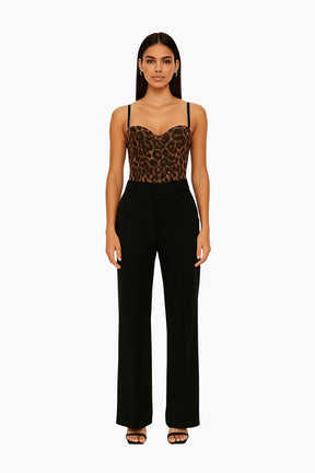 Woman wearing a leopard print top and black pants