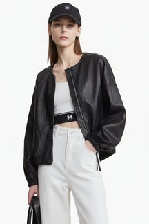 Person wearing a black leather jacket, white top, and pants 