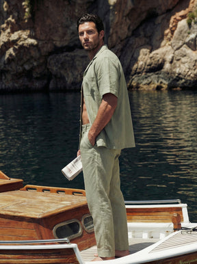 Man standing on a boat by rocky cliffs