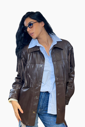 Woman wearing a brown leather jacket over a light blue shirt