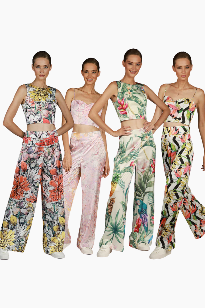 Four models wearing floral and patterned pants with matching tops