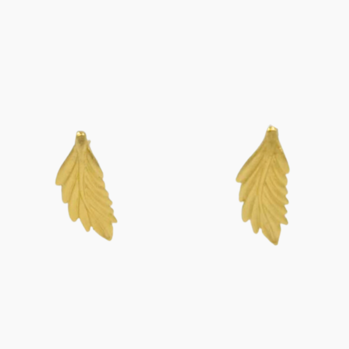 Gold feather-shaped earrings on a white background