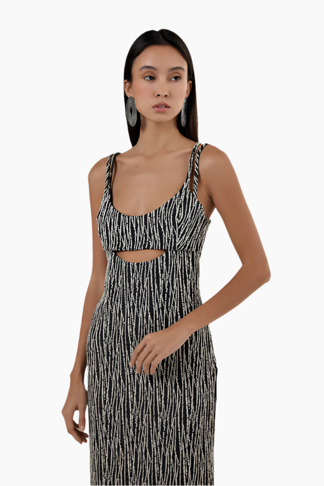 Woman wearing a black and white patterned dress , Straight ankle length dress, straight fit, middle front cut out.