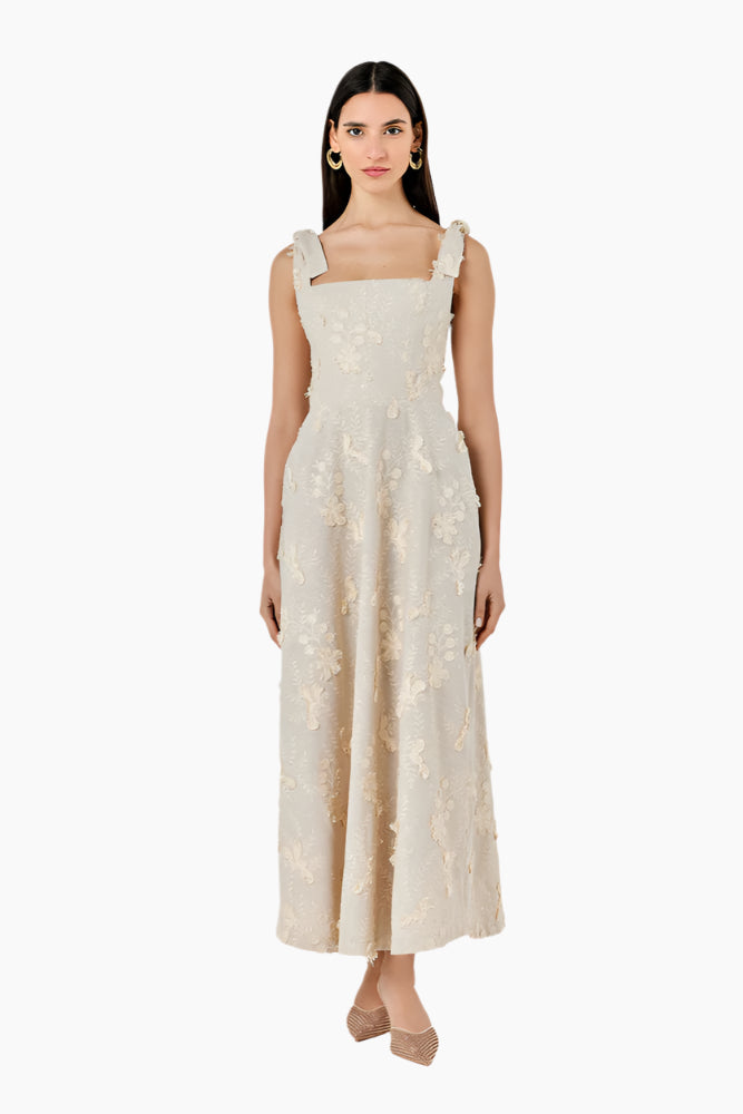 Woman wearing a beige lace dress Fitted corset-like ankle-length dress with adjustable straps, a flared skirt, and a middle back zipper.