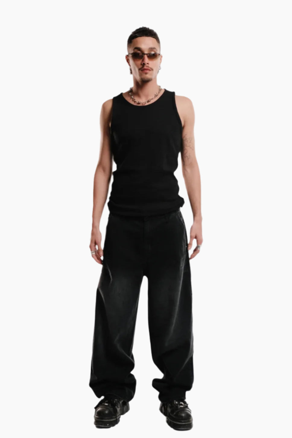 Person wearing a black sleeveless top and pants 