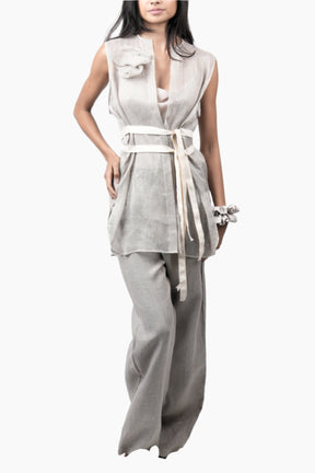 Woman wearing a sleeveless top and wide-leg pants with a belt 