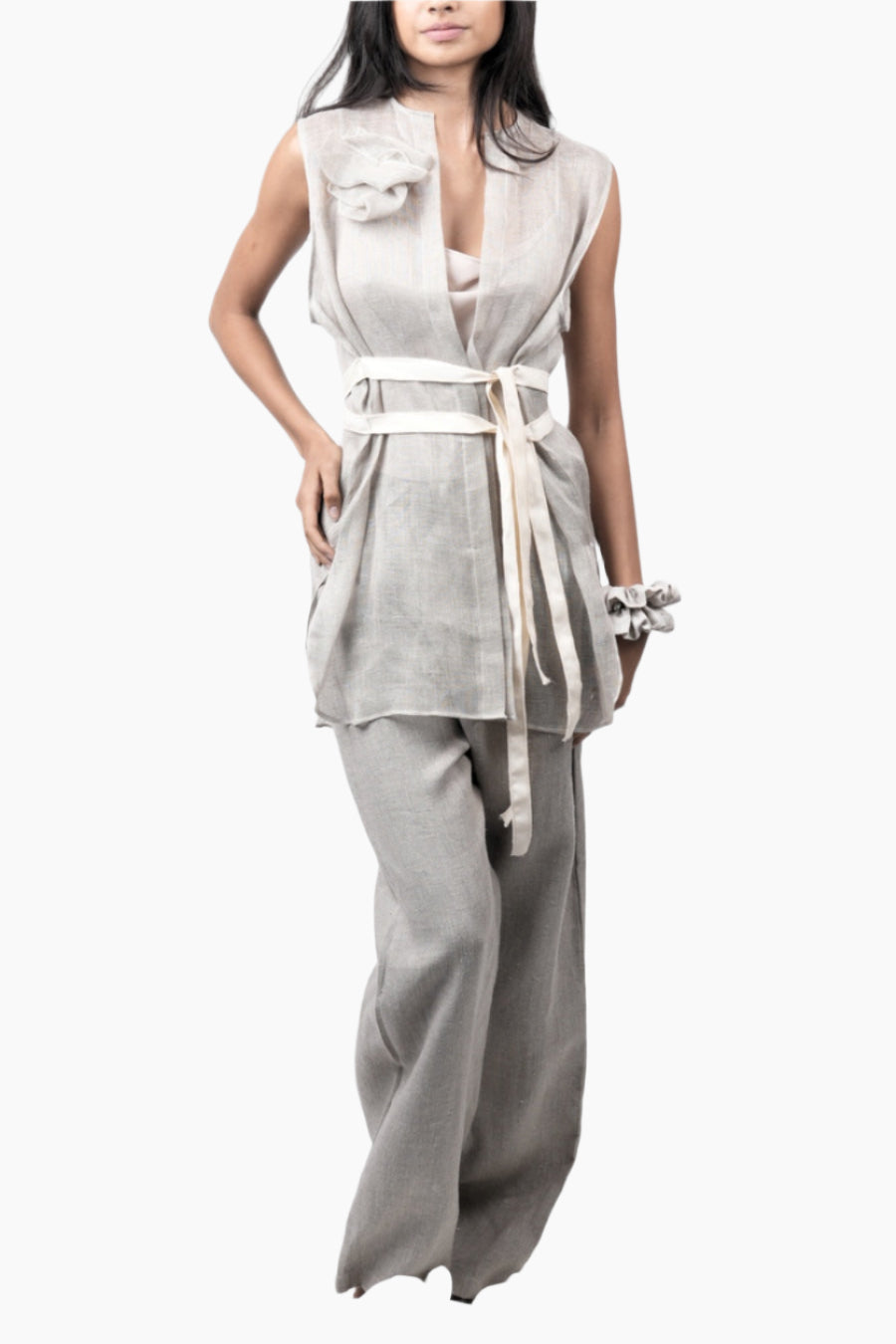 Woman wearing a sleeveless top and wide-leg pants with a belt 