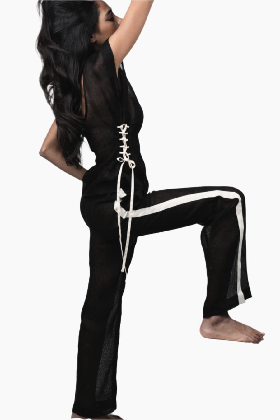 Person wearing a black outfit with white lace-up details and white stripes 
