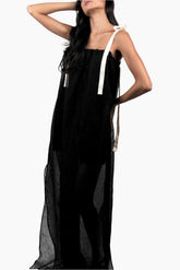 Woman wearing a black dress with white straps 
