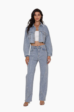 Woman wearing a light blue denim jacket and jeans on a white background