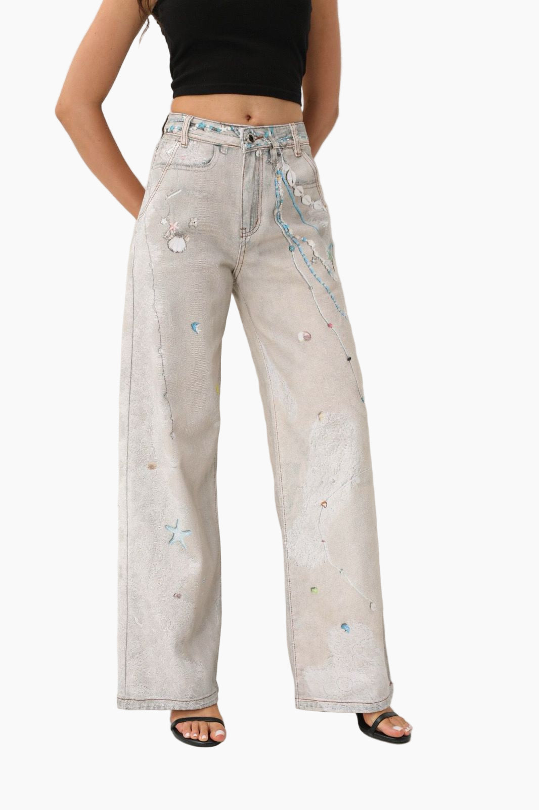 Light-colored jeans with decorative elements worn by a person 
