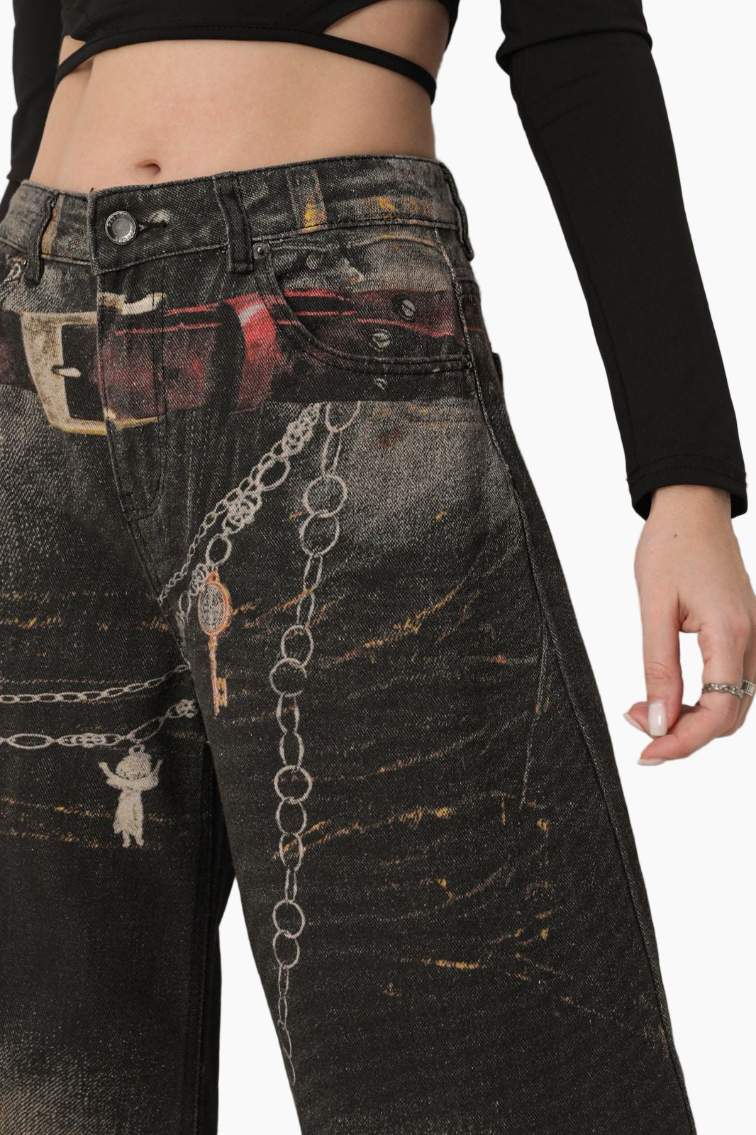 Black distressed jeans with chain details worn by a person 