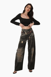 Woman wearing a black crop top and distressed black pants 