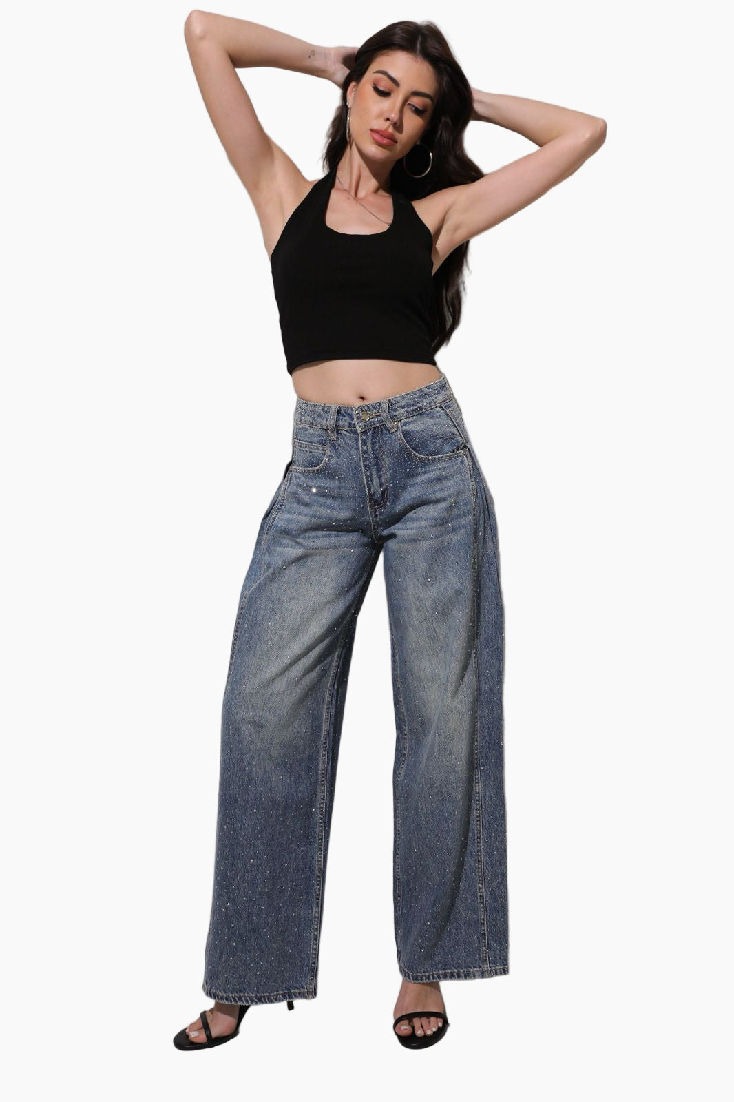 Woman wearing a black crop top and blue jeans