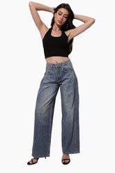 Woman wearing a black crop top and blue jeans