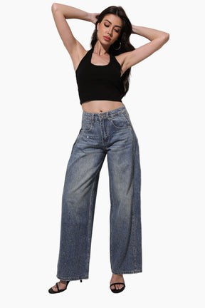 Woman wearing a black crop top and blue jeans
