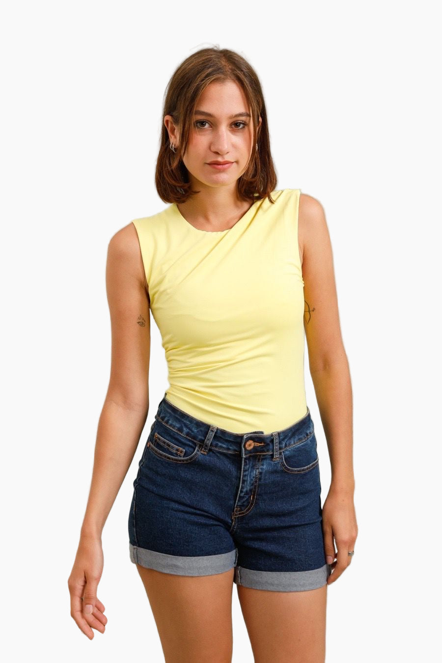 Woman wearing a yellow top and blue shorts