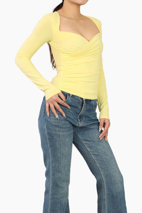 Yellow long-sleeve top worn by a person