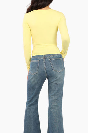 Yellow long-sleeve top worn by a person