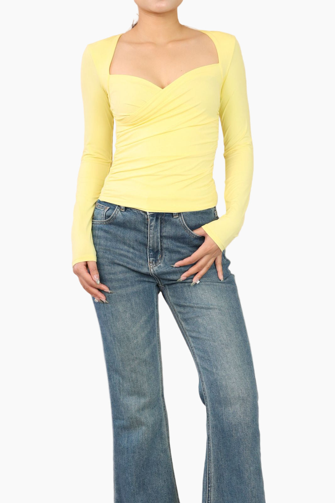Person wearing a yellow long-sleeve top and blue jeans 