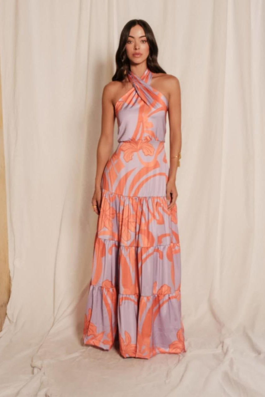 Woman wearing a patterned dress against a plain background