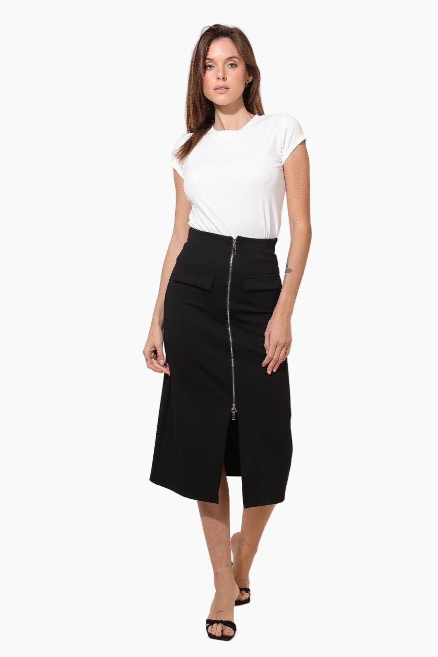 Woman wearing a black skirt with a front zipper and a white top 