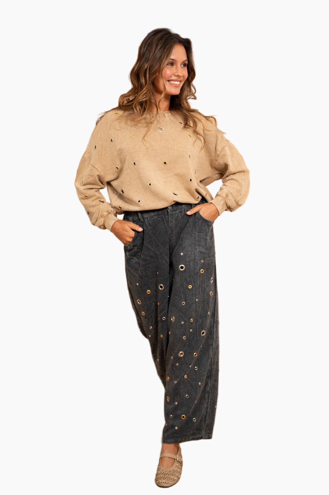 Woman wearing a beige blouse and dark pants with a pattern 