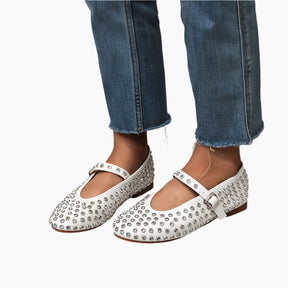 White flats with silver embellishments worn with blue jeans 