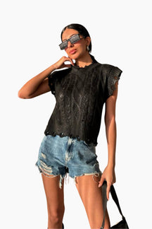 Woman wearing a black sleeveless top and denim shorts 