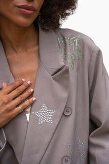Close-up of a gray blazer with star-shaped embellishments 