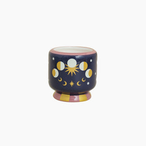 Decorative candle holder with celestial design on a white background