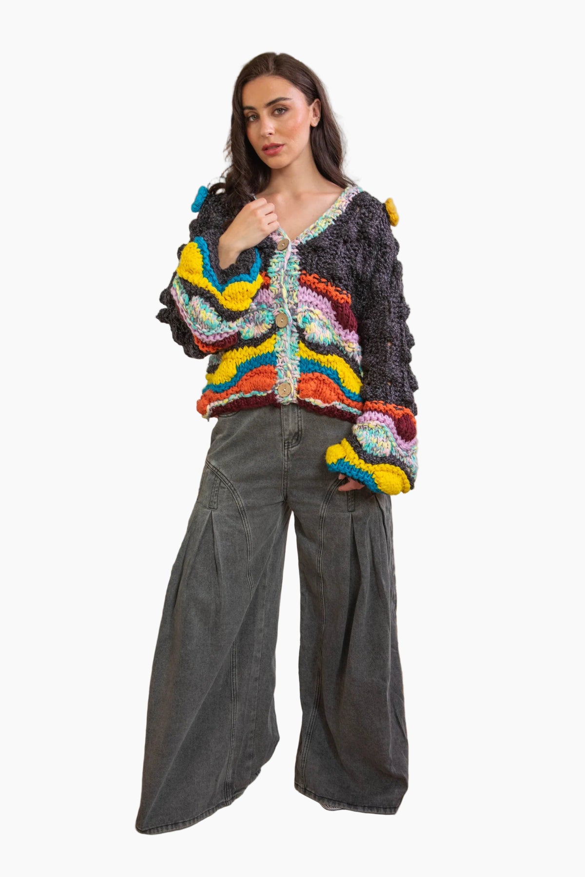 Woman wearing a colorful knitted sweater and gray wide-leg pants