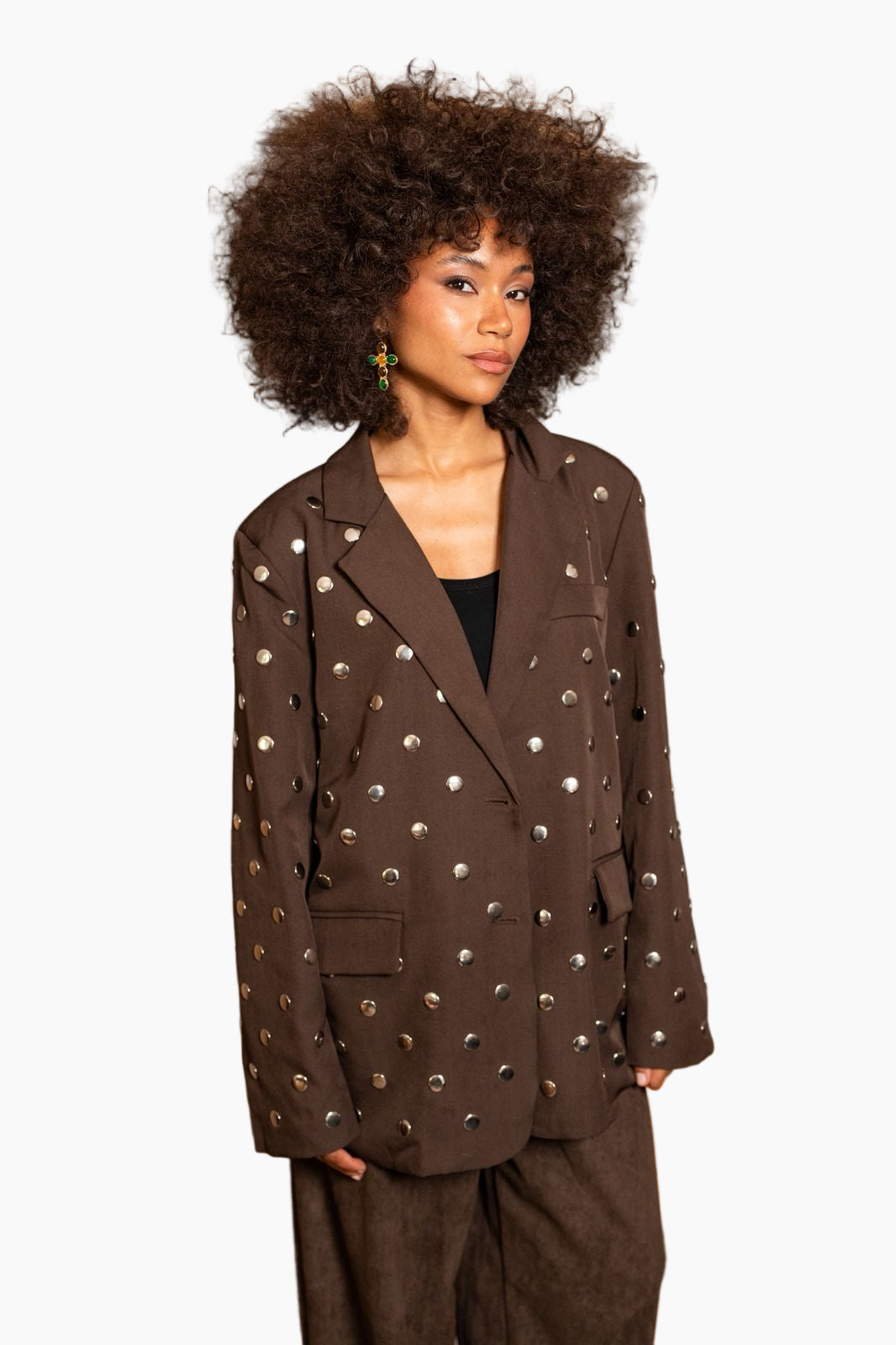 Woman wearing a brown blazer with decorative studs 